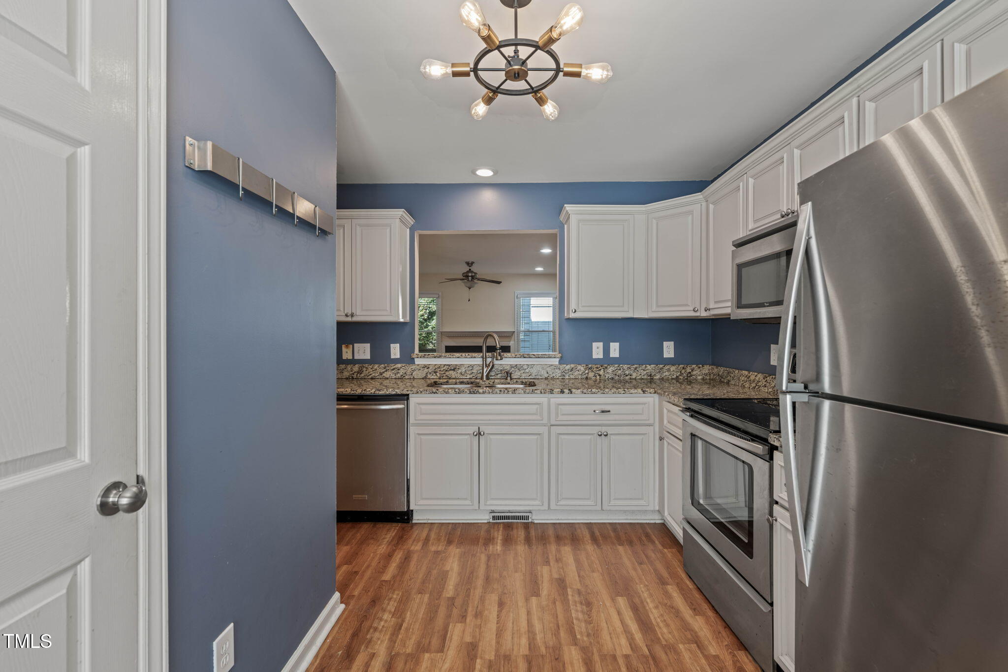 6051 Epping Forest Drive Raleigh, NC 27613 - Photo 5 of 26 a kitchen with stainless steel appliances granite countertop a refrigerator a sink dishwasher a stove and white countertops with wooden floor