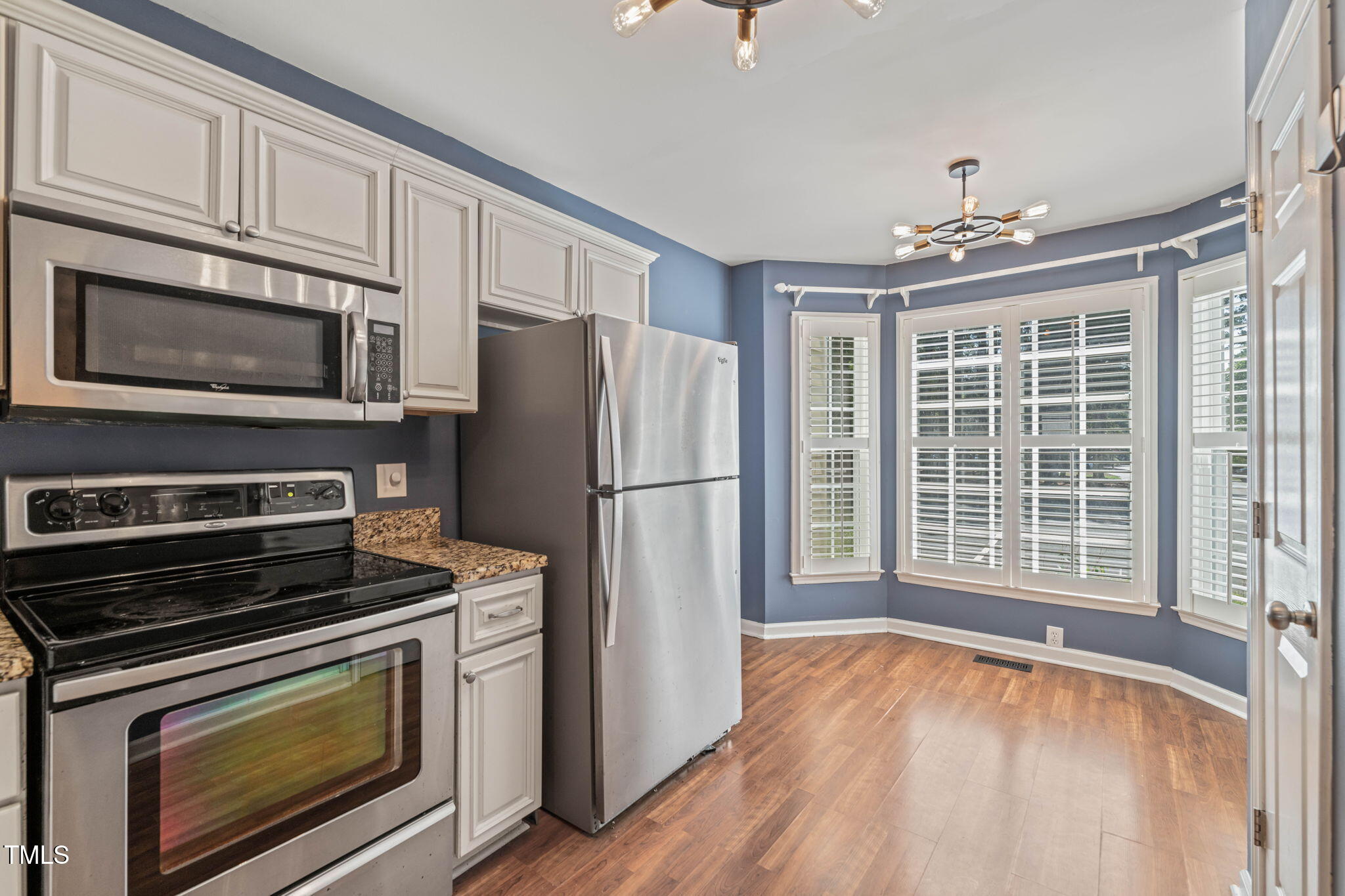 6051 Epping Forest Drive Raleigh, NC 27613 - Photo 9 of 26 a kitchen with granite countertop a refrigerator stove and microwave