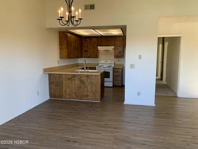 a kitchen with stainless steel appliances granite countertop a sink cabinets and wooden floor