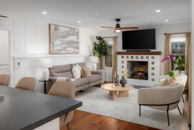 a kitchen with stainless steel appliances granite countertop a stove a sink a dining table and chairs with wooden floor