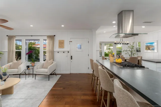 a living room with furniture kitchen view and a large window
