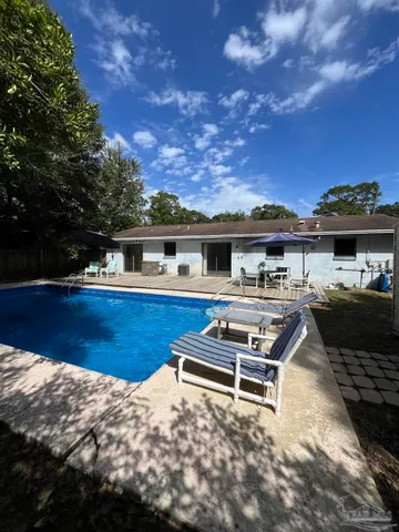 a backyard of a house with table and chairs