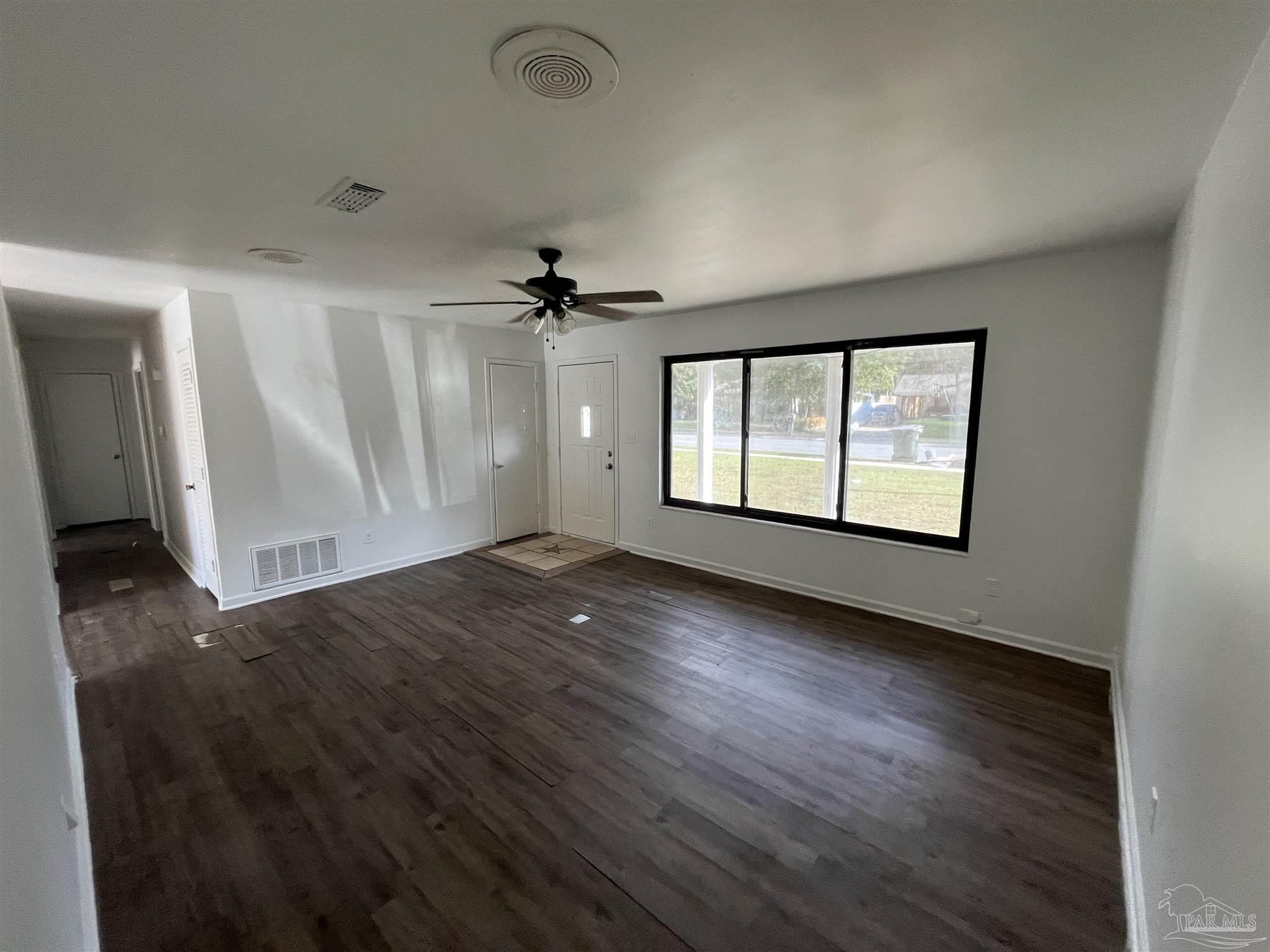4511 St Nazaire Road Pensacola, FL 32505 - Photo 5 of 21 an empty room with wooden floor and windows