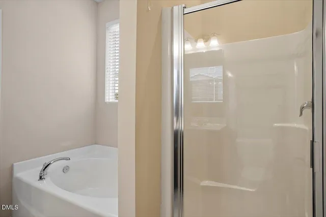 a white bath tub sitting next to a shower