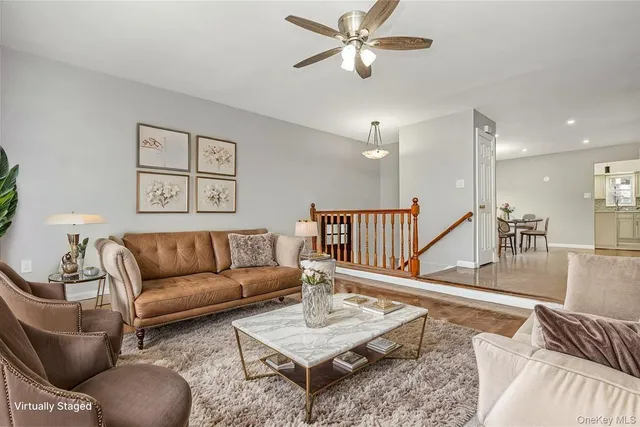 a living room with furniture and a view of kitchen
