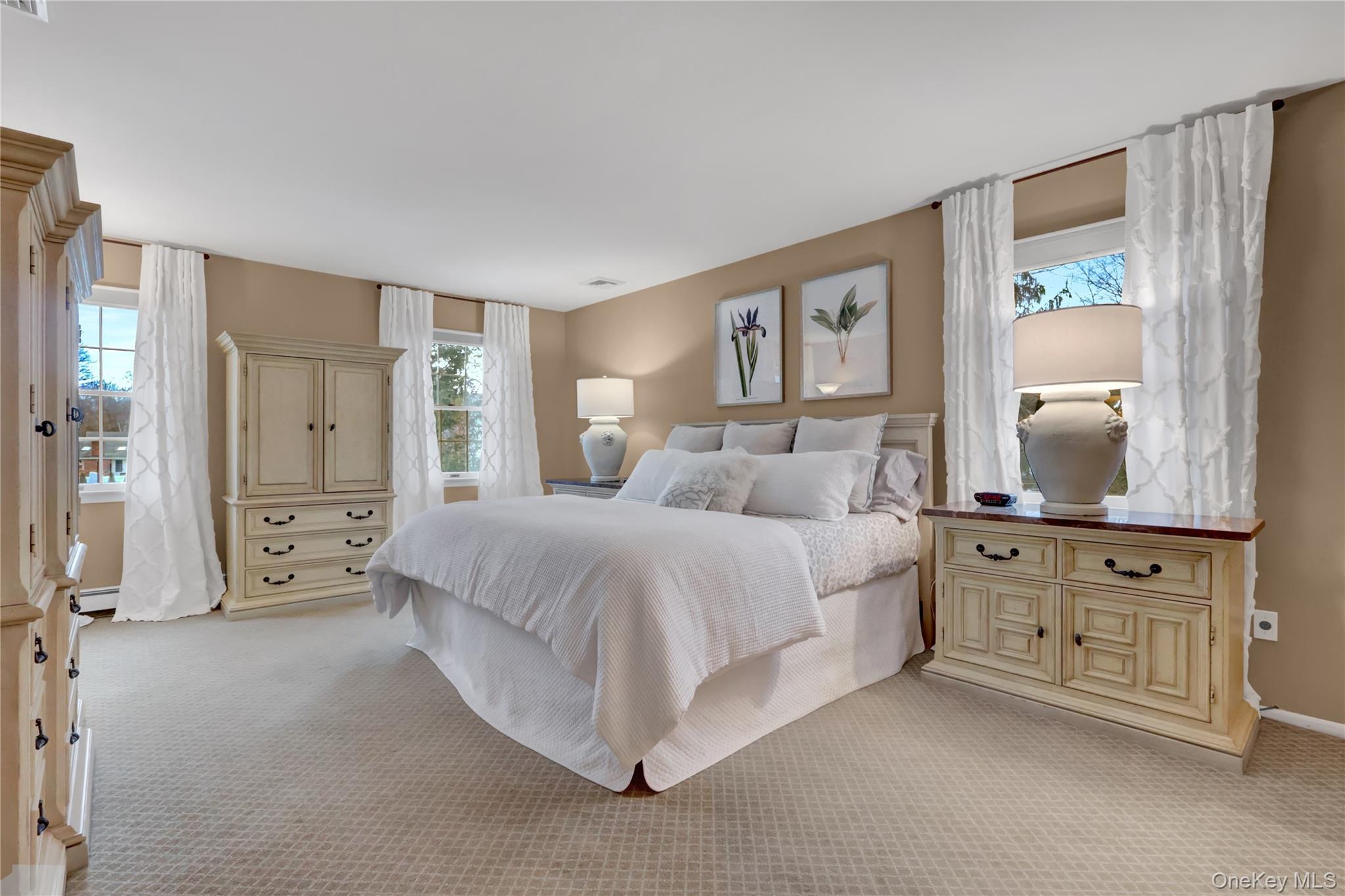 6 Samuels Path Miller Place, NY 11764 - Photo 26 of 47 a spacious bedroom with a bed a dresser and mirror
