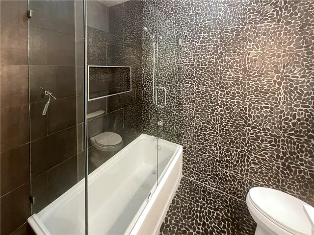 a bathroom with a toilet and a shower