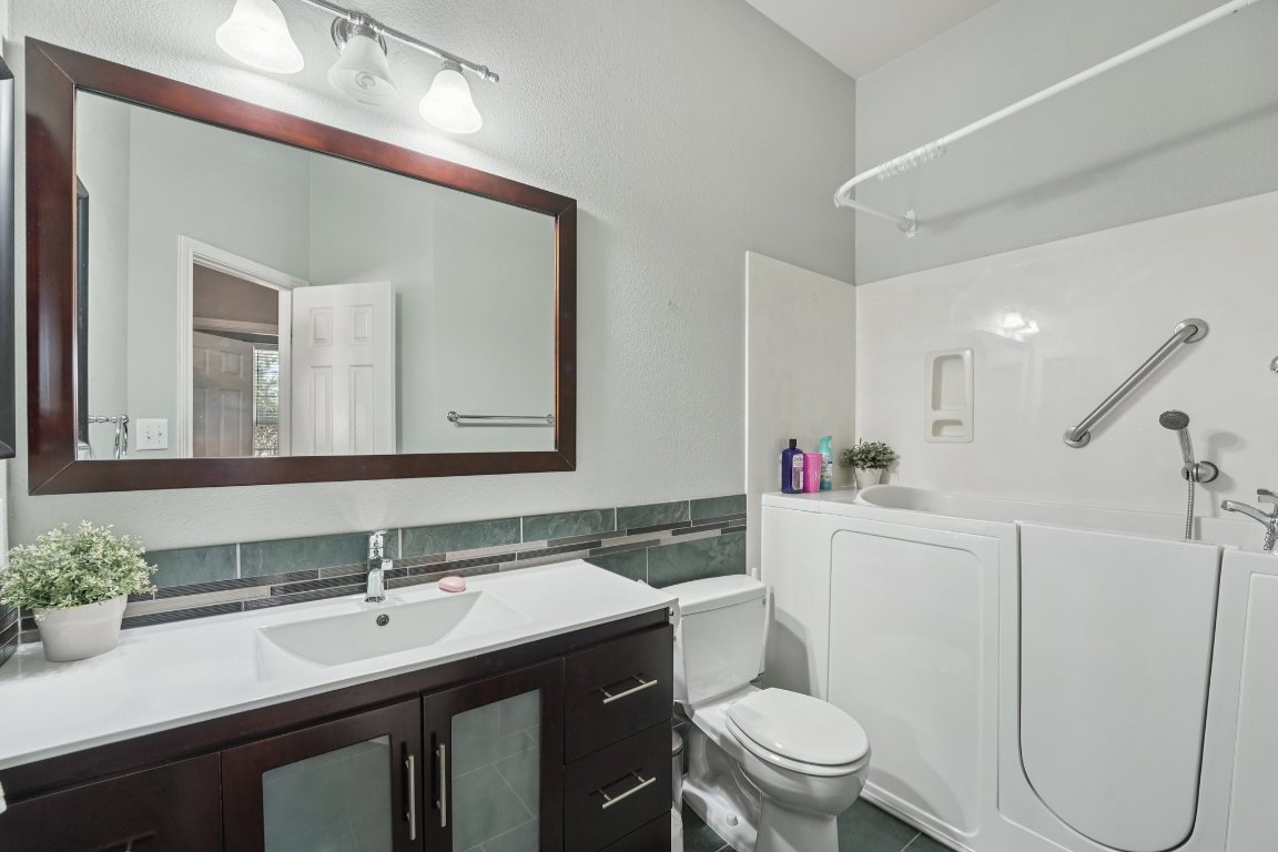 1105 Pigeon Forge Road Pflugerville, TX 78660 - Photo 10 of 19 a bathroom with a sink a toilet a mirror and shower