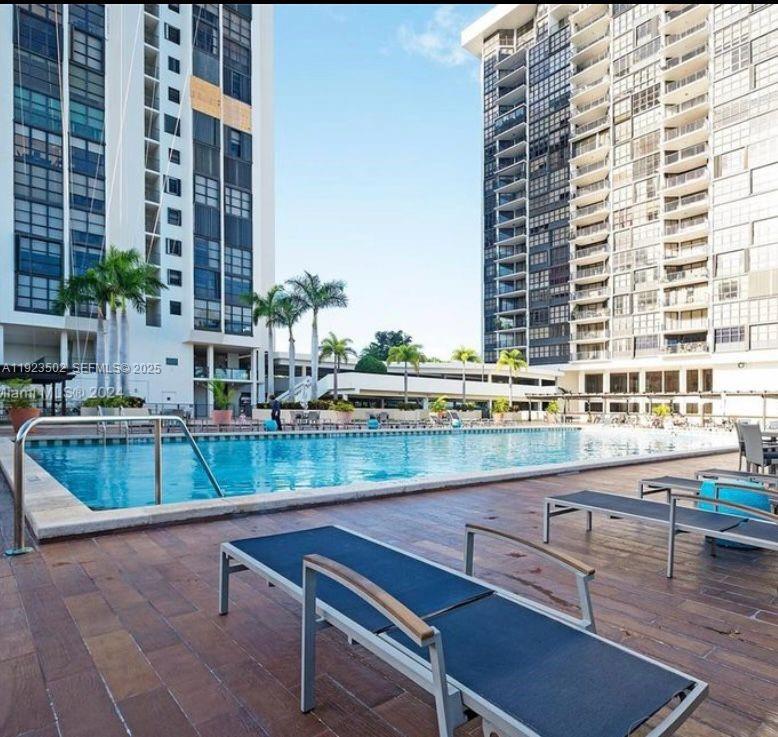 1865 Brickell Avenue, Unit A604 Miami, FL 33129 - Photo 18 of 18 a table and chairs sitting in a roof deck with a barbeque