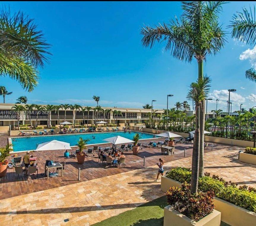 1865 Brickell Avenue, Unit A604 Miami, FL 33129 - Photo 2 of 18 a view of a swimming pool with lawn chairs under an umbrella