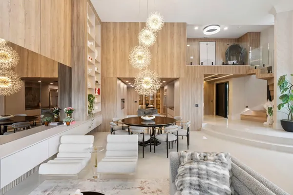 a dining room with furniture a floor to ceiling window and wooden floor