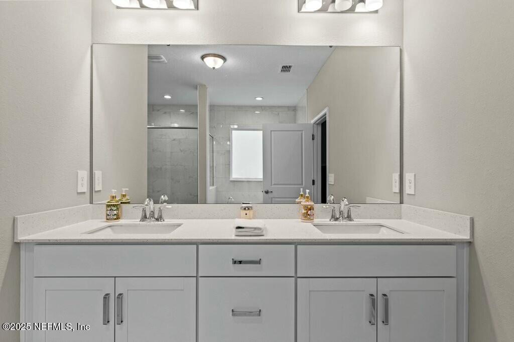 469 Archstone Way St. Augustine, FL 32092 - Photo 37 of 59 a bathroom with a sink vanity and a mirror