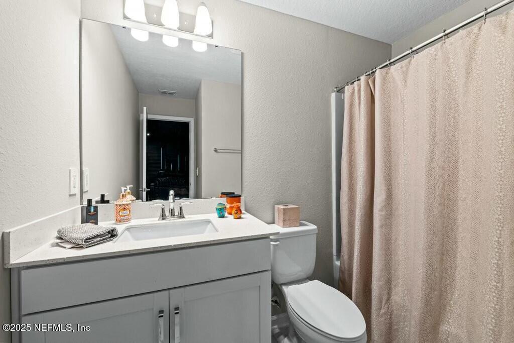 469 Archstone Way St. Augustine, FL 32092 - Photo 45 of 59 a bathroom with a sink a toilet and shower curtain