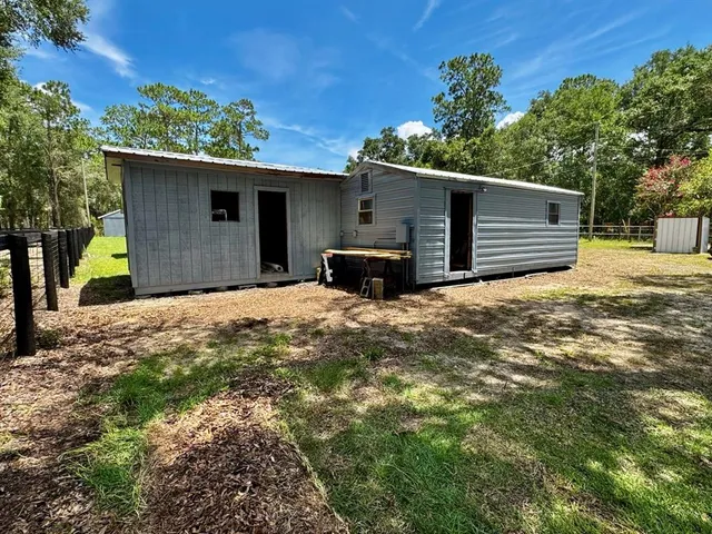 a view of a house with large trees and a yard