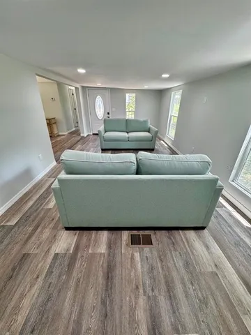 a living room with furniture and a wooden floor
