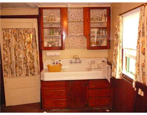 18W Budlong Farm Road Warwick, RI 02886 - Photo 6 of 12 Kitchen. The porcelain tub/sink with double drain board and the maple cabinet/cupboard add to the rustic embrace of the cottage; a throw-back to the days when there was no hot water heater and dish water had to be heated on the stove.