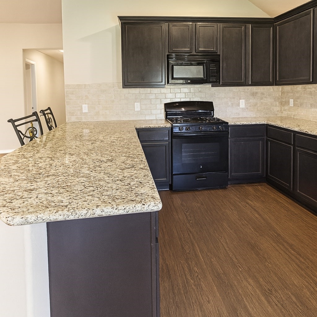 54 Rodeo Crest Drive Manvel, TX 77578 - Photo 4 of 10 a kitchen with granite countertop a stove and cabinets