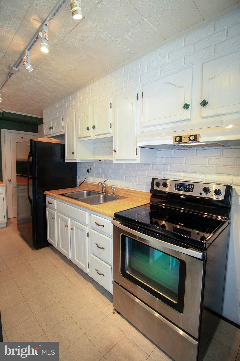 8427 Pleasant Plains Road Baltimore, MD 21286 - Photo 15 of 30 a kitchen with stainless steel appliances a stove a microwave and cabinets