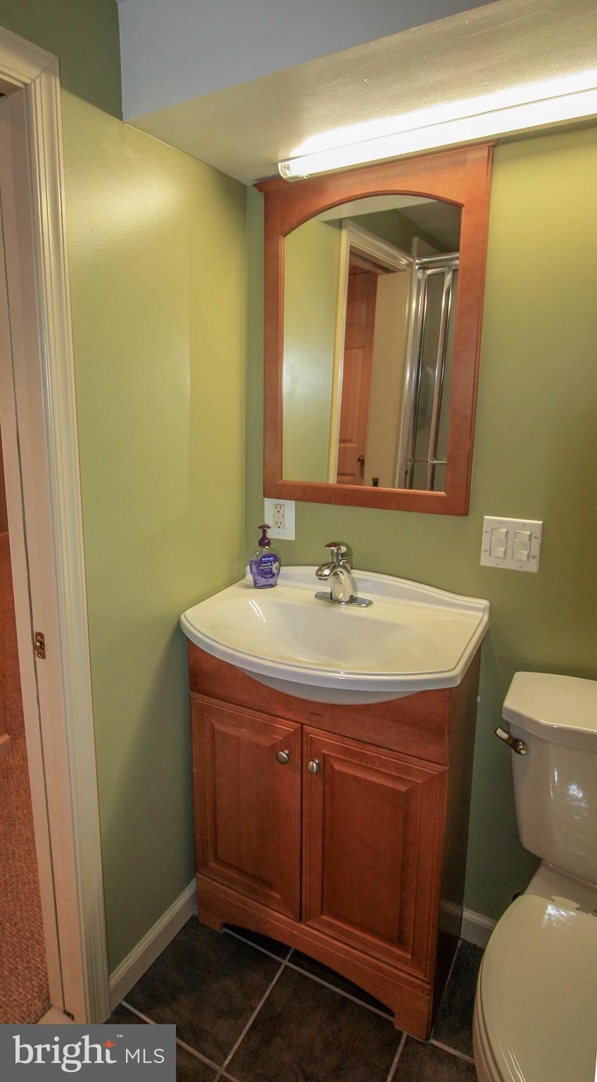 8427 Pleasant Plains Road Baltimore, MD 21286 - Photo 29 of 30 a bathroom with a sink a toilet and mirror