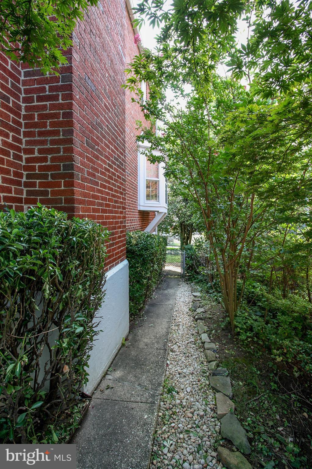 8427 Pleasant Plains Road Baltimore, MD 21286 - Photo 4 of 30 a pathway of a house with potted plants and a yard