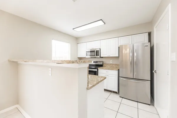 a kitchen with stainless steel appliances a refrigerator sink and microwave