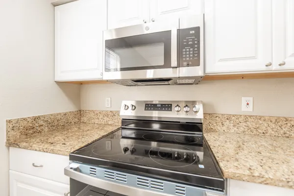 a stove top oven sitting inside of a kitchen