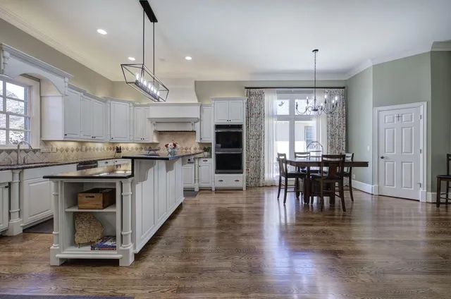 a kitchen with granite countertop a sink stainless steel appliances and cabinets