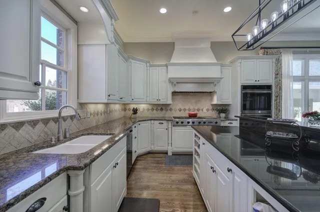 a kitchen with granite countertop a refrigerator and cabinets