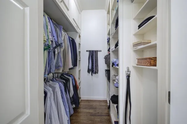a spacious bedroom with a bed a chandelier and large window