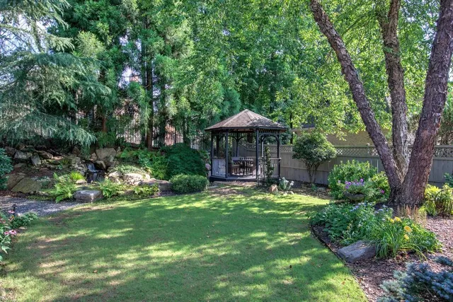 a view of a dining room and livingroom with furniture wooden floor a chandelier