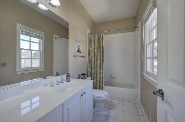 a bathroom with a toilet a sink a bathtub and a mirror