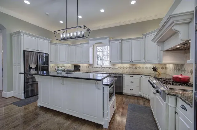 a spacious bedroom with a large bed and a chandelier