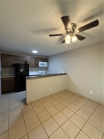 a view of kitchen with stainless steel appliances cabinets and ceiling fan