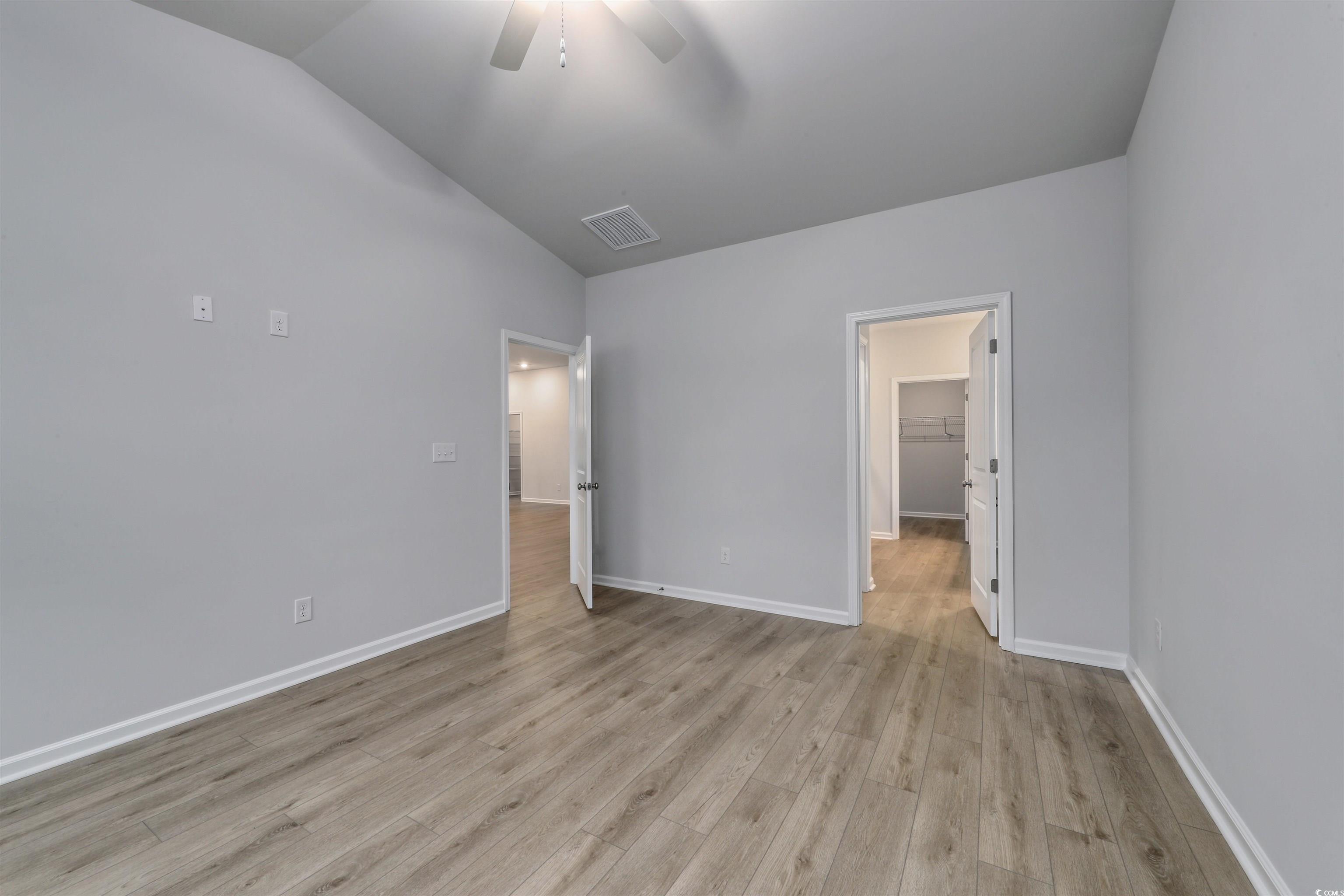 370 Garden Grove Street Conway, SC 29526 - Photo 14 of 28 Unfurnished bedroom featuring vaulted ceiling, light wood-style floors, a ceiling fan, and a walk in closet