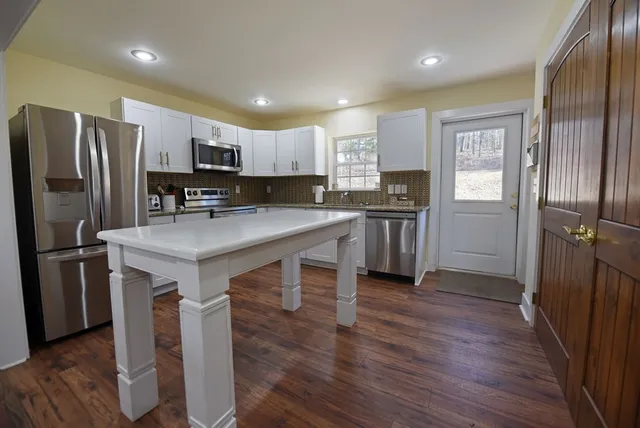 a kitchen with kitchen island a refrigerator stove and sink