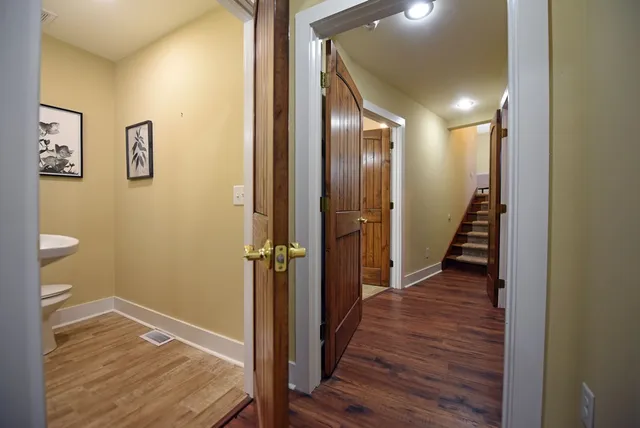 a view of a hallway with wooden floor and staircase