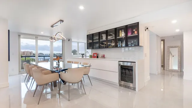 a dining room with stainless steel appliances kitchen island a table and chairs in it