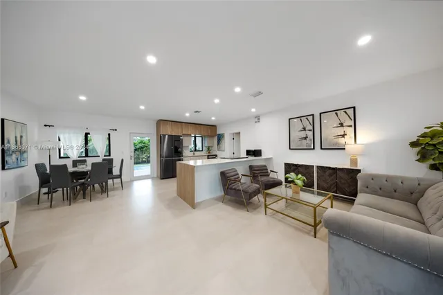 a living room with furniture and a dining table with kitchen view