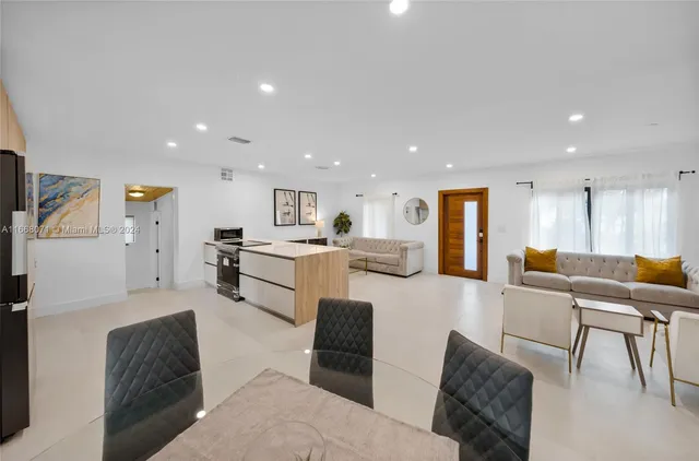 a living room with furniture and a dining table with kitchen view