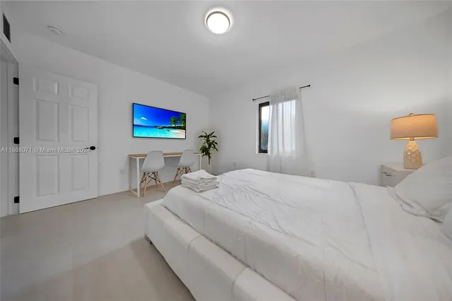 a bedroom with a bed and a painting on the wall