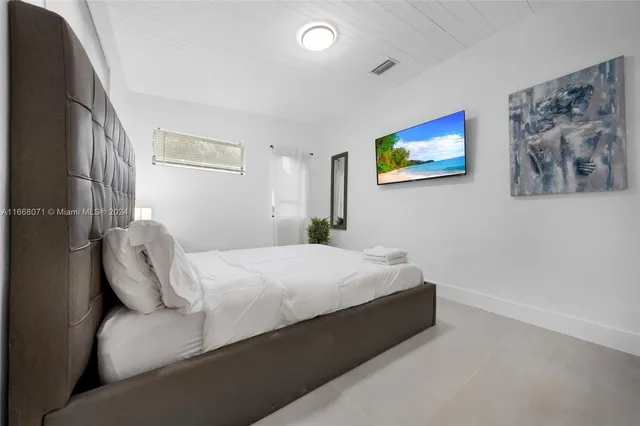 a bedroom with a bed and a painting on the wall