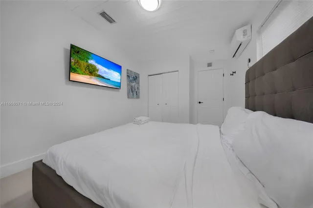 a bedroom with a bed and a painting on the wall