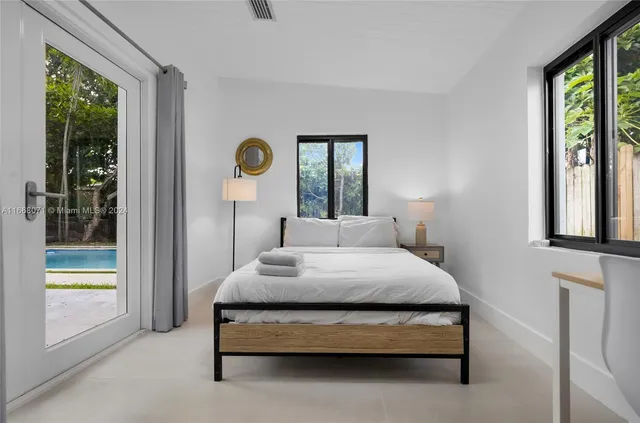 a bedroom with a bed a table and painting on the wall