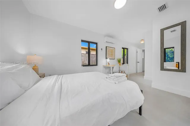 a bedroom with a large bed and a chandelier