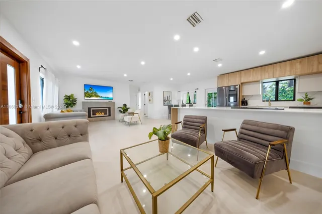 a living room with furniture and a kitchen view