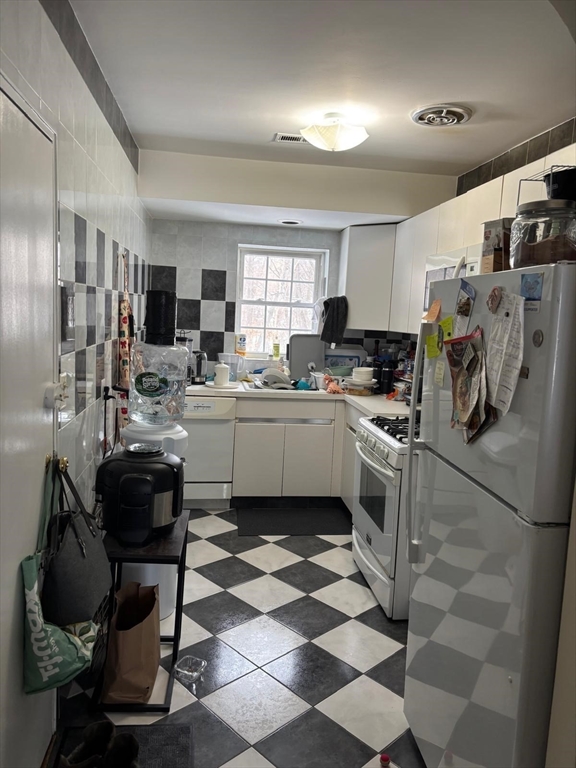 125 Lake Shore Road, Unit 4 Boston, MA 02135 - Photo 2 of 9 a kitchen with a sink a stove a refrigerator and cabinets