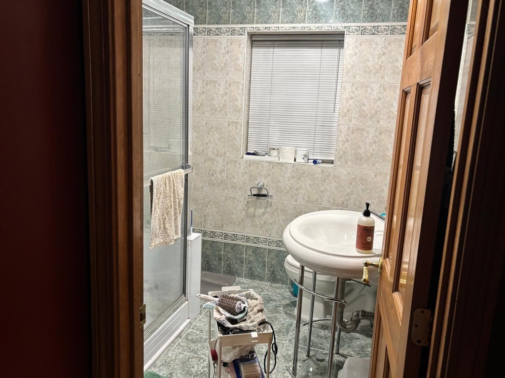 125 Lake Shore Road, Unit 4 Boston, MA 02135 - Photo 4 of 9 a bathroom with a sink and a mirror