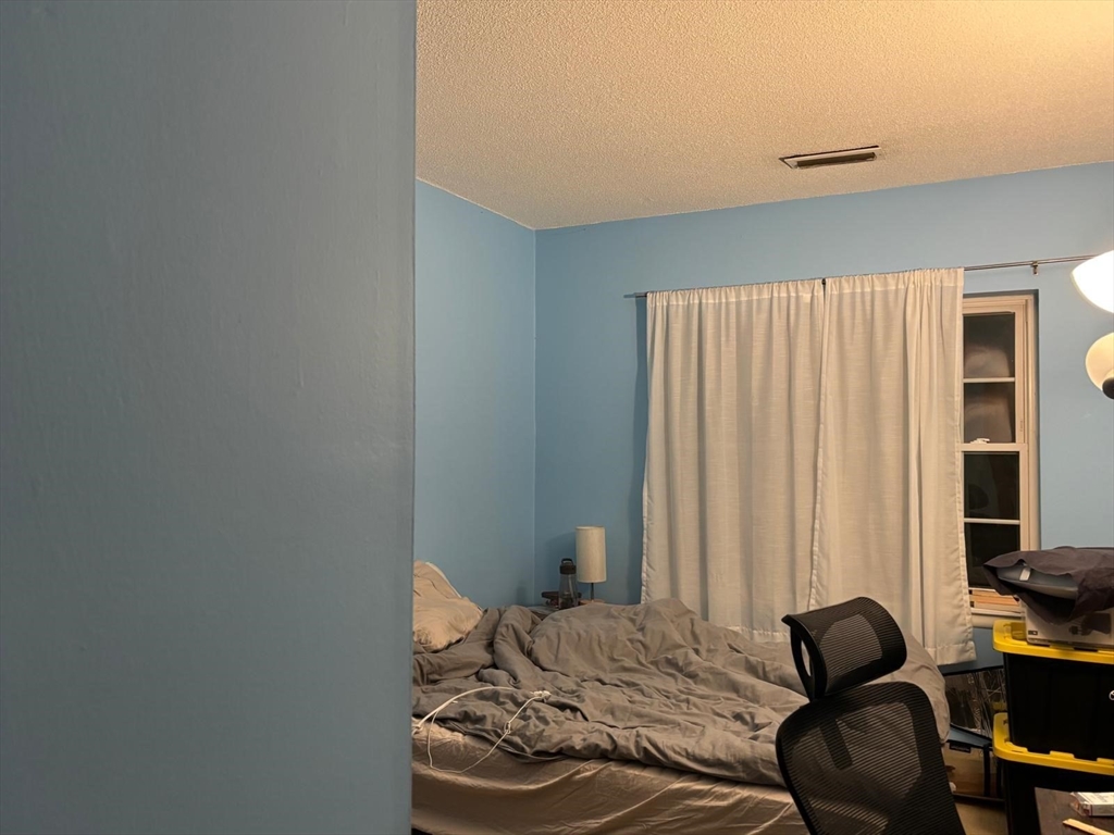 125 Lake Shore Road, Unit 4 Boston, MA 02135 - Photo 6 of 9 a bedroom with a bed and a window