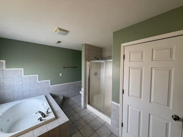 a bathroom with a tub shower and vanity