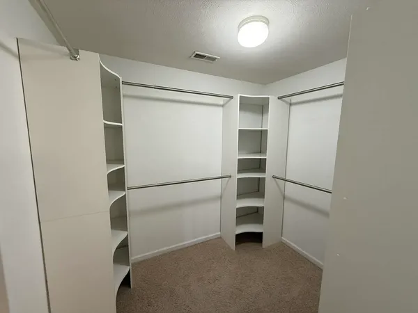a view of walk in closet with empty racks